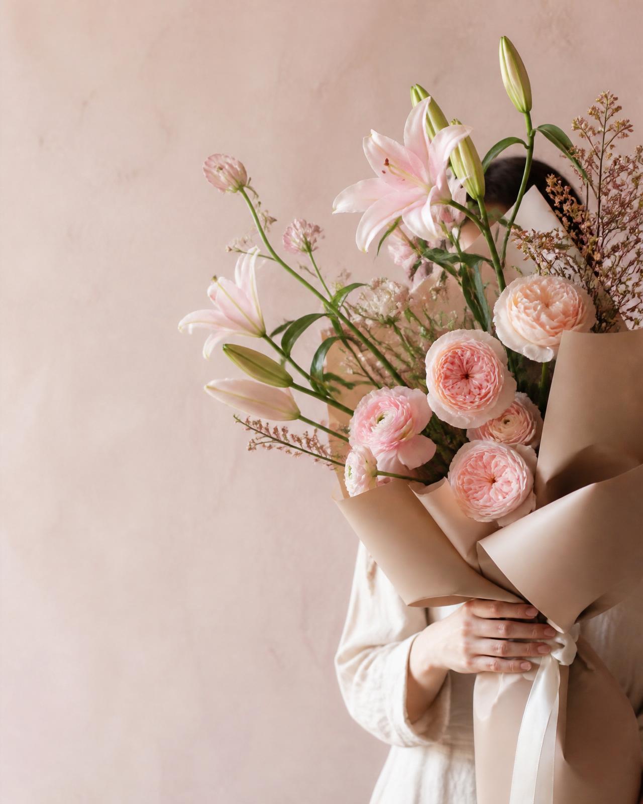 Cream and blush bouquet in a nude vase by a sunlit window